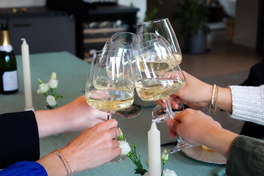 Proosten met glazen witte wijn
